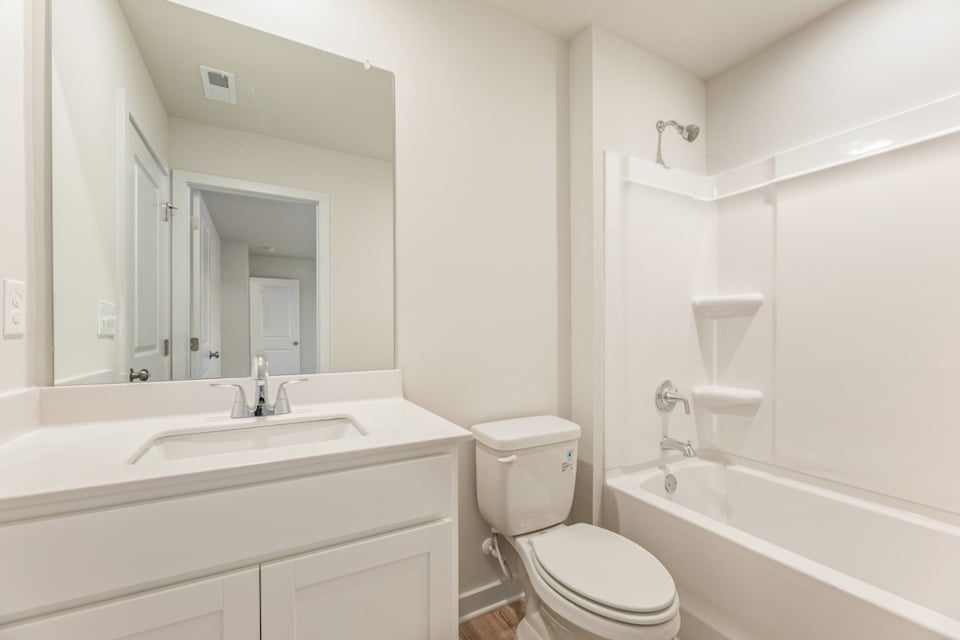 A bathroom with a tub toilet and sink.