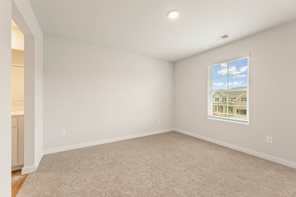 A room with a window and a carpet.