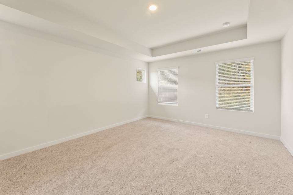 A room with a carpet and a window.