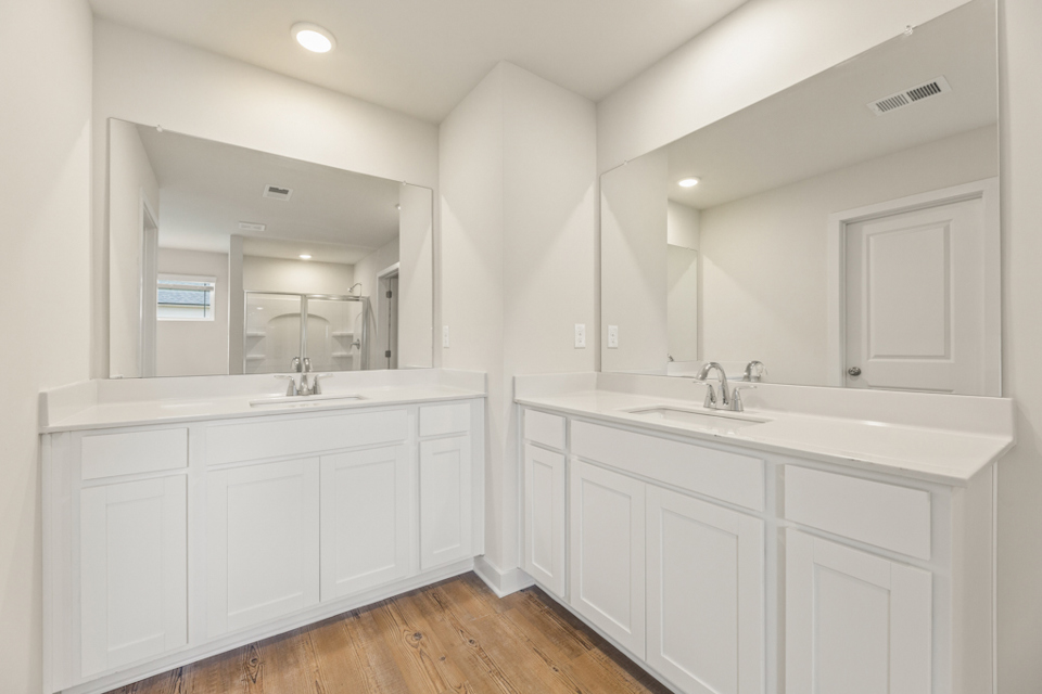 A bathroom with white cabinets.