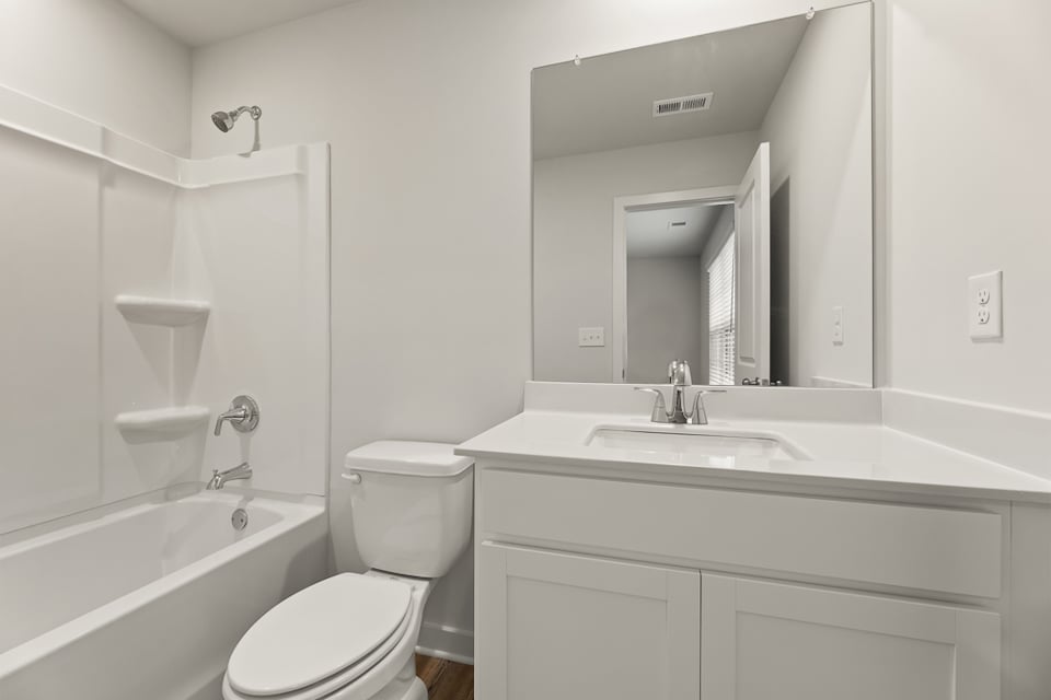 A bathroom with a tub sink and toilet.