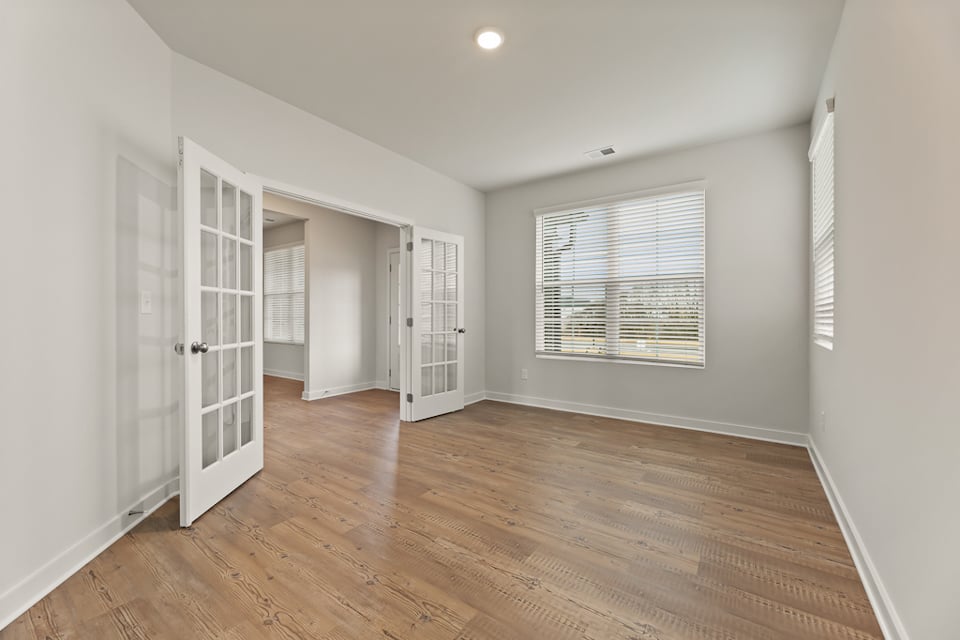 A room with white walls and wood floors.