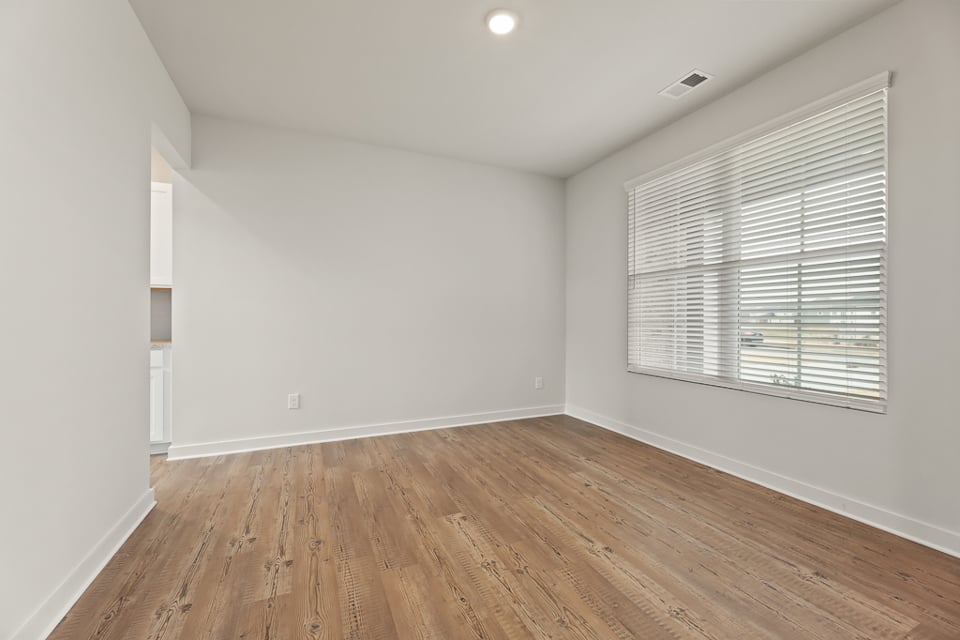 A room with a wood floor and a window.