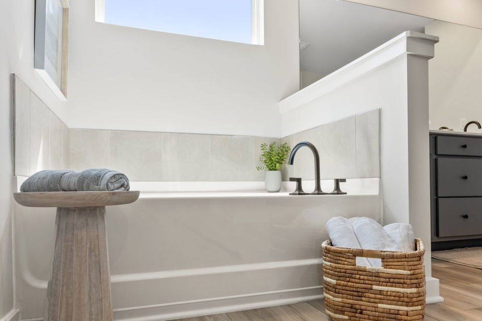 A bathtub with a basket and towels in it.