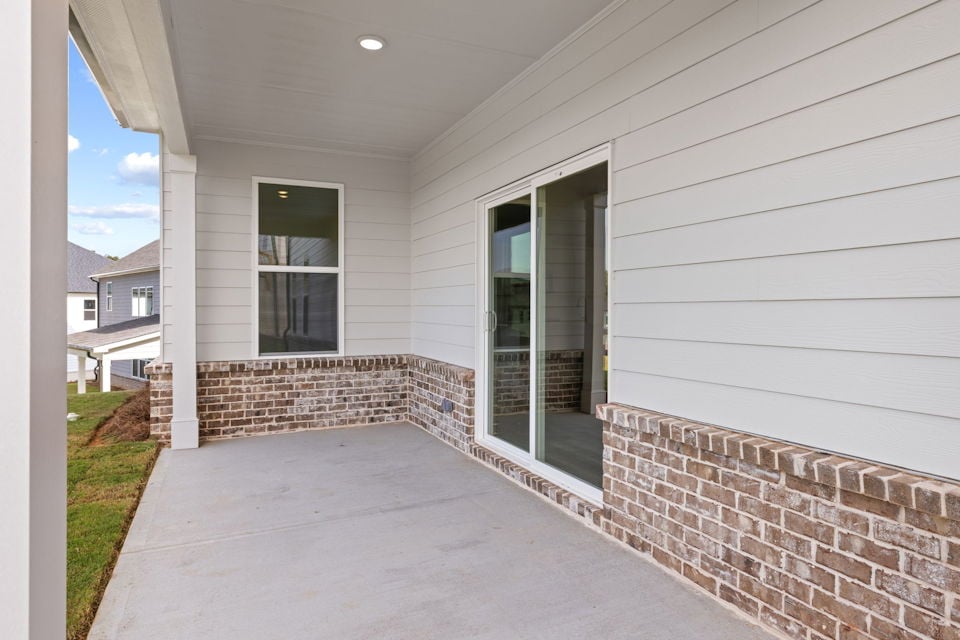A white house with a brick patio.