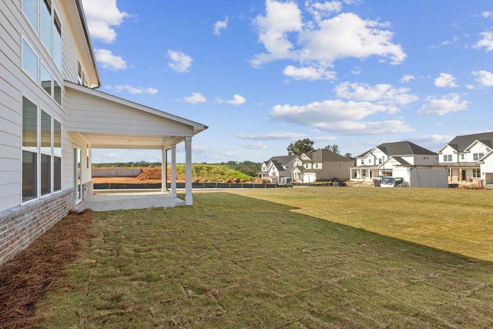 A grassy area with buildings in the background.
