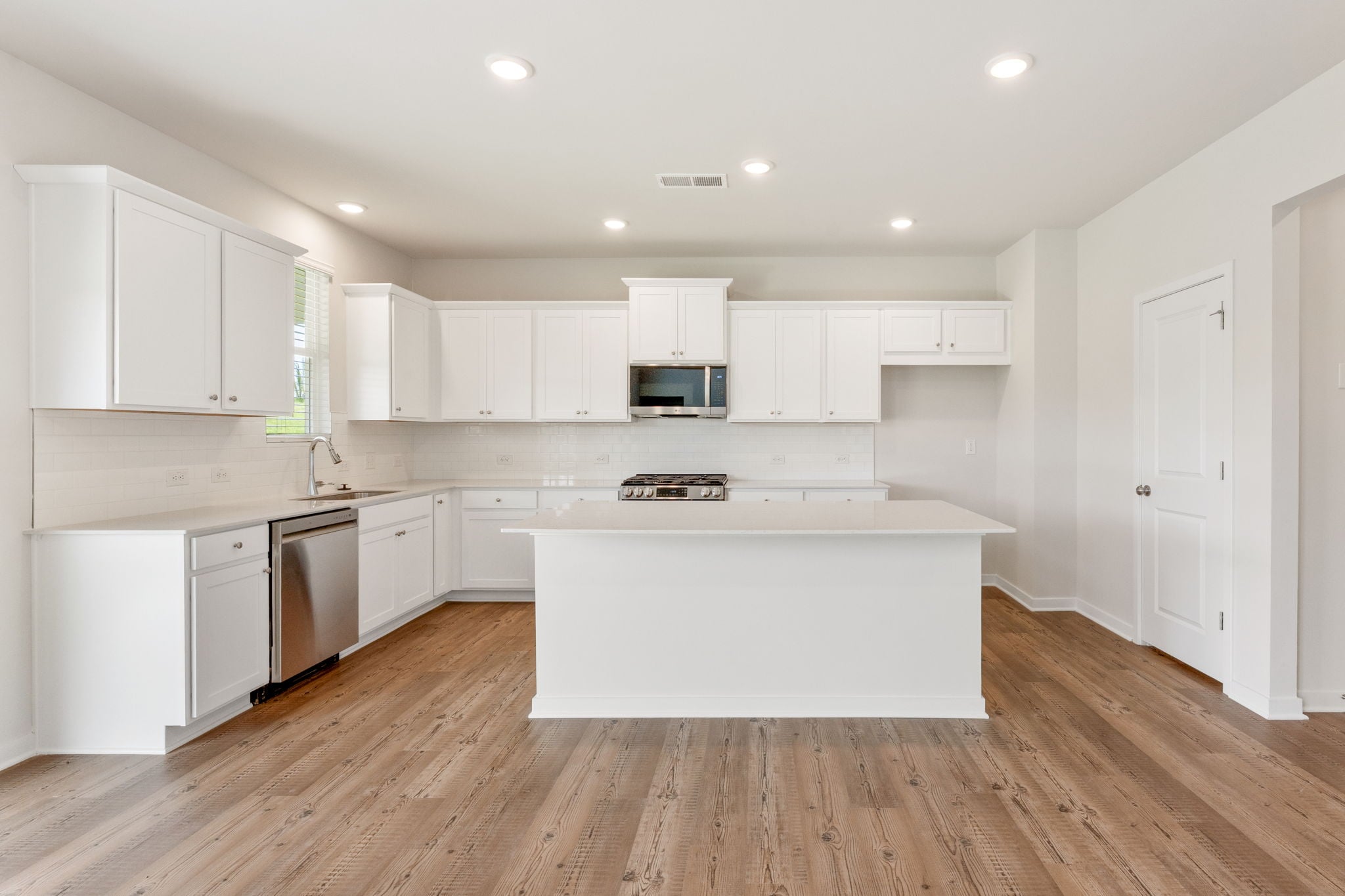 A kitchen with white cabinets.