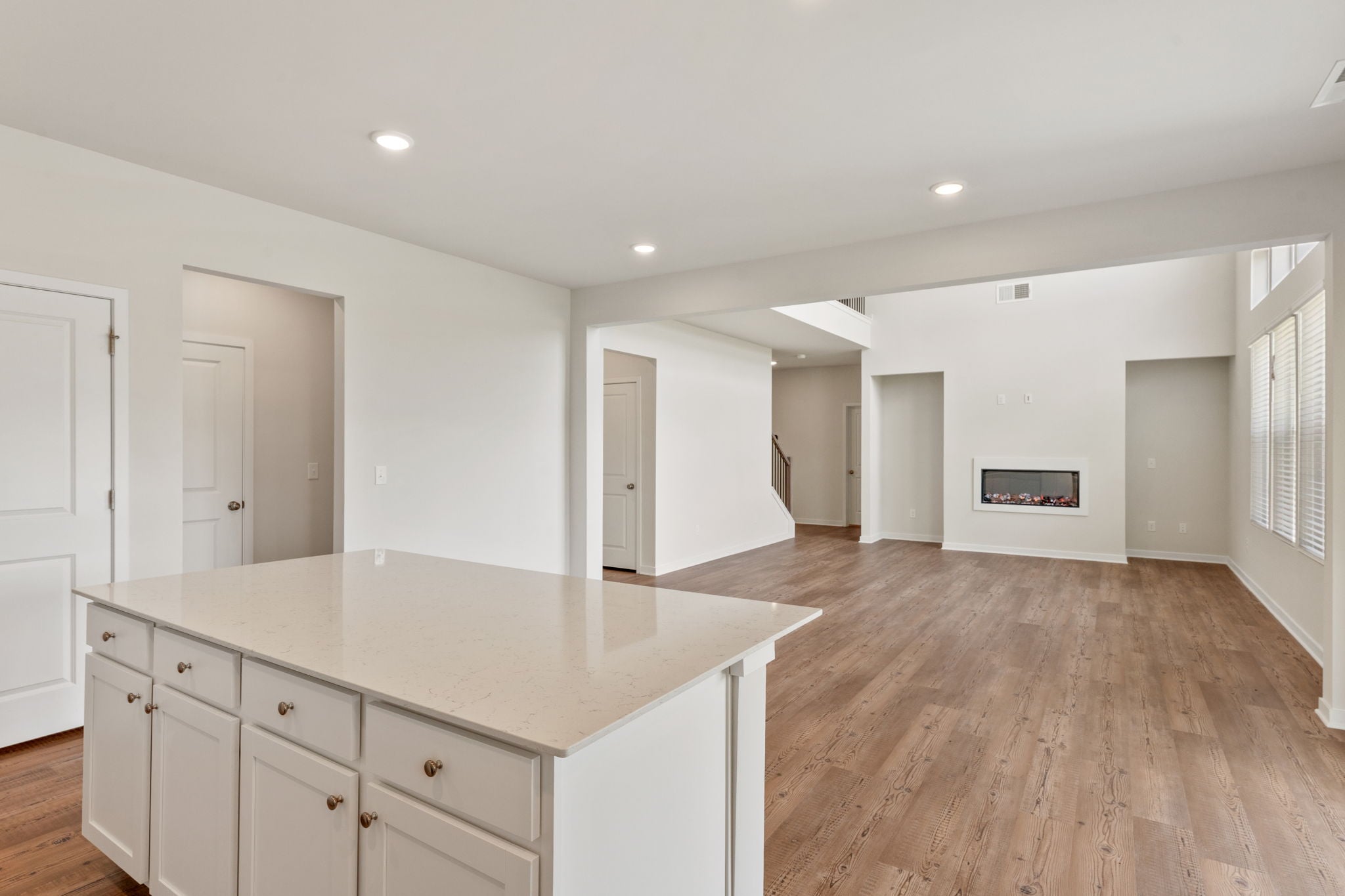 A large empty room with white cabinets.