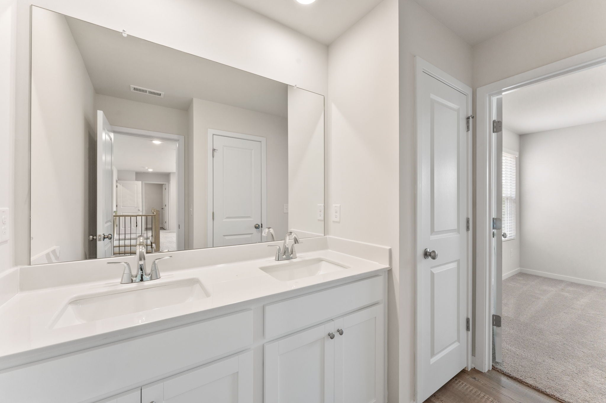 A bathroom with white cabinets.