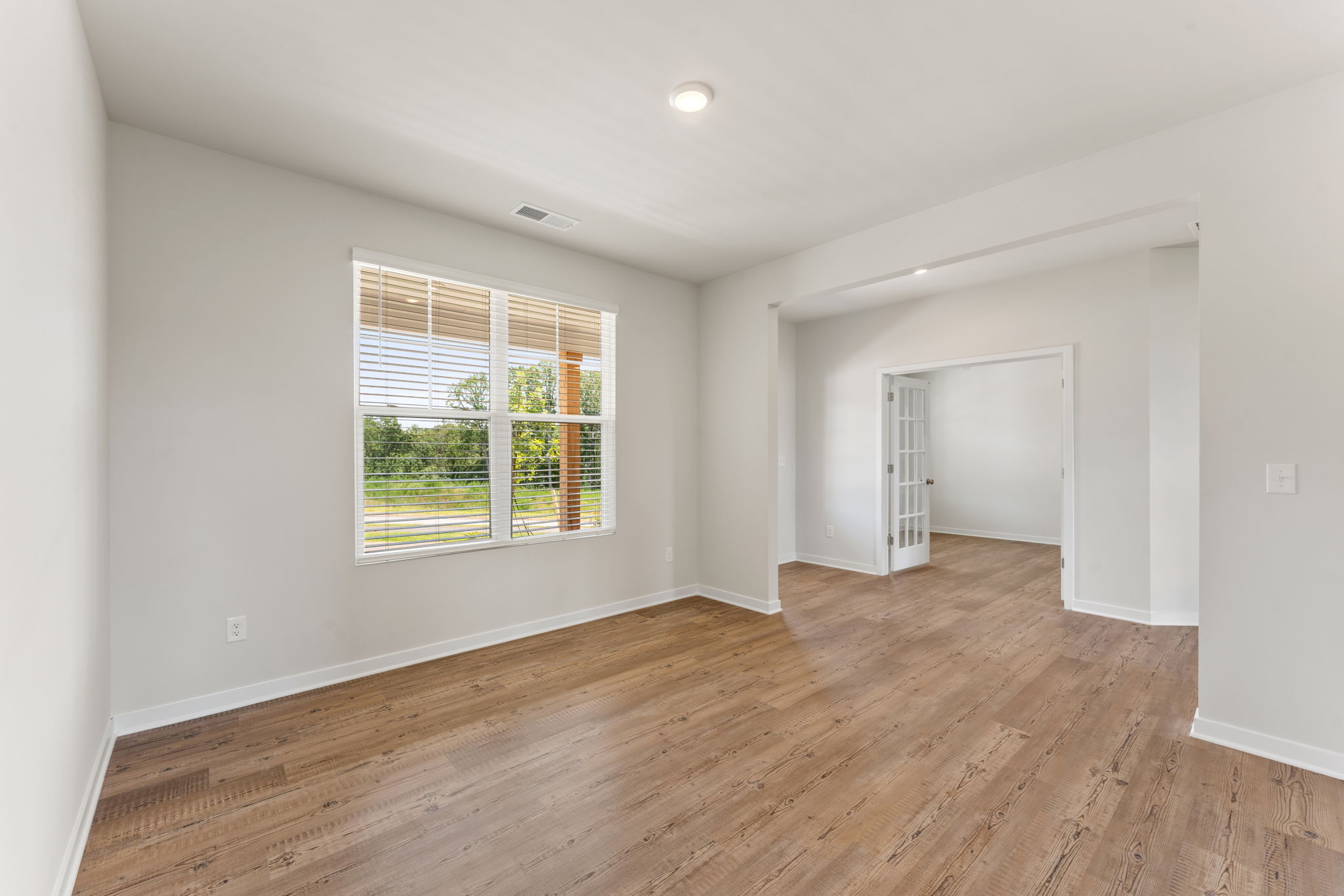 A room with a wood floor and a window.