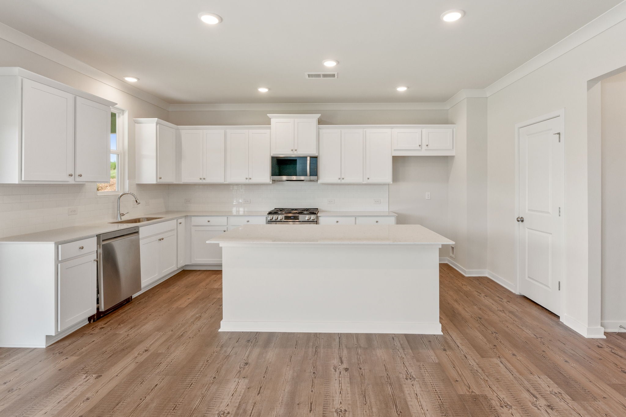 A kitchen with white cabinets.