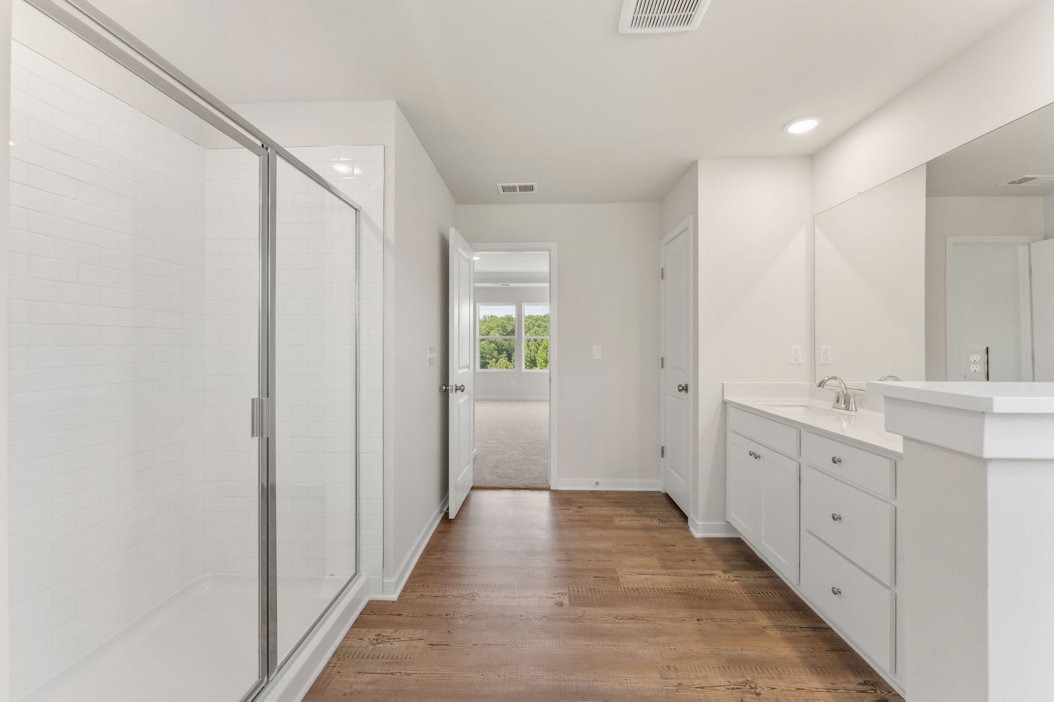 A bathroom with white cabinets.