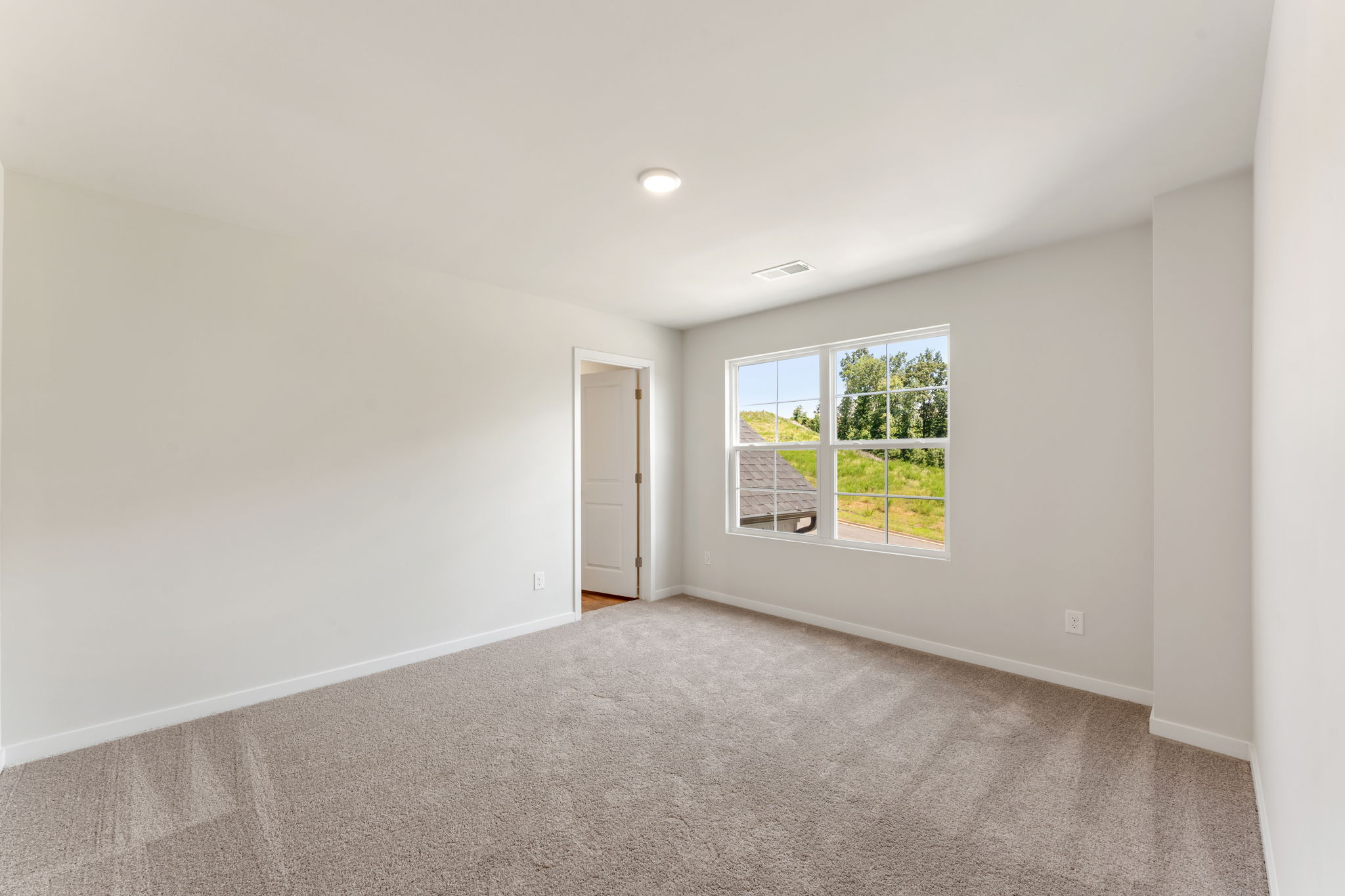A room with a window and a carpet.