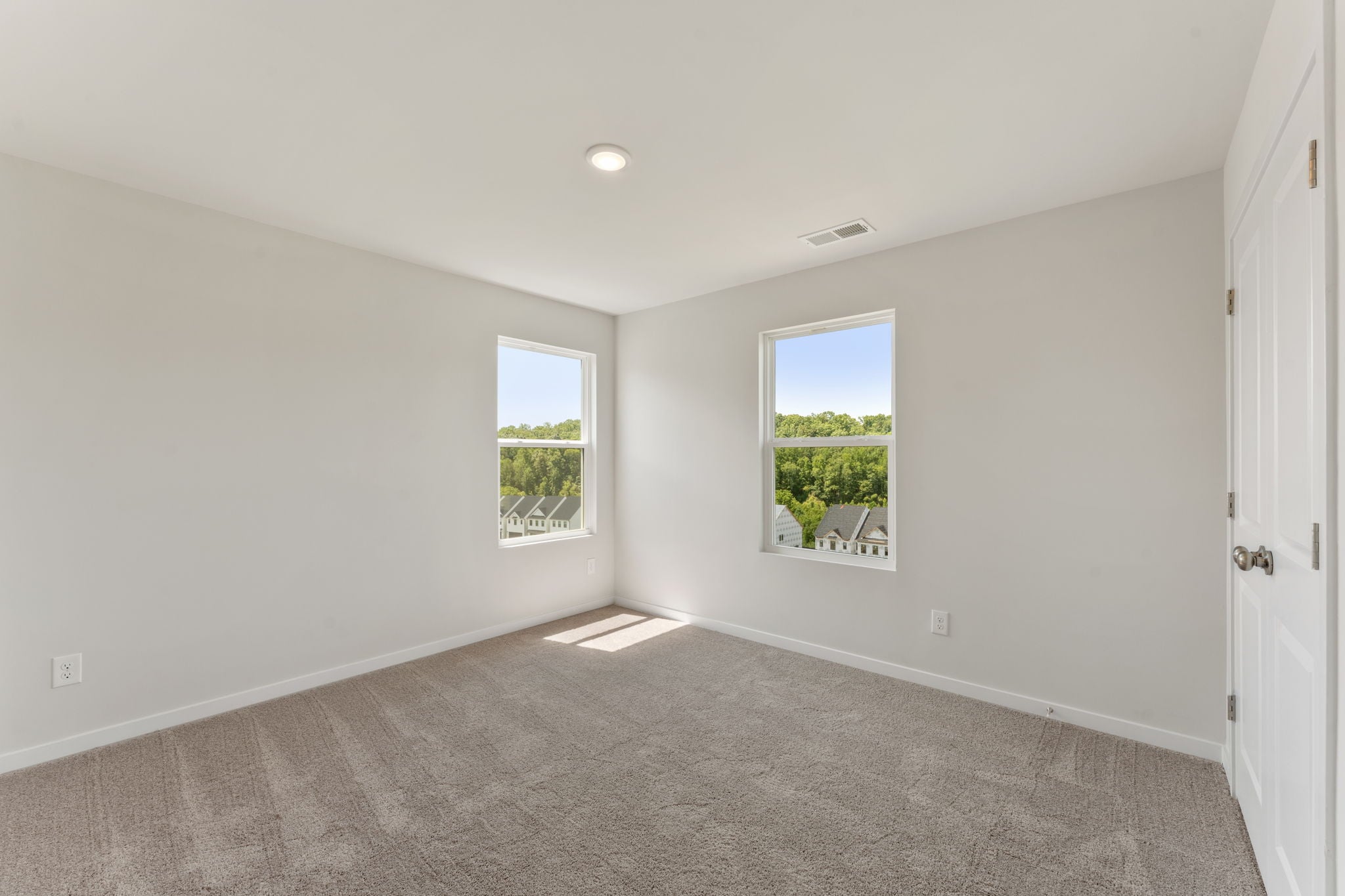 A room with windows and a rug.