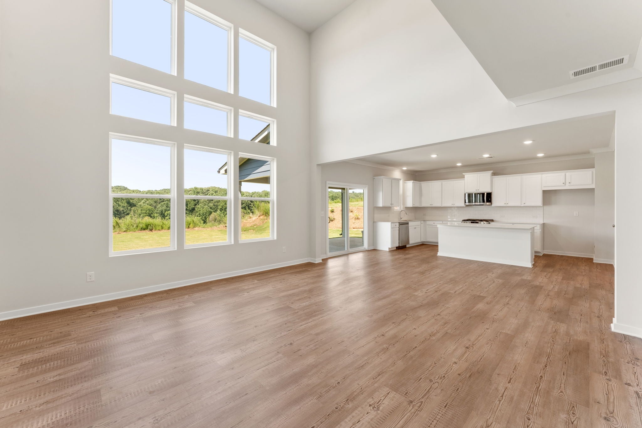 A large empty room with a wood floor and windows.