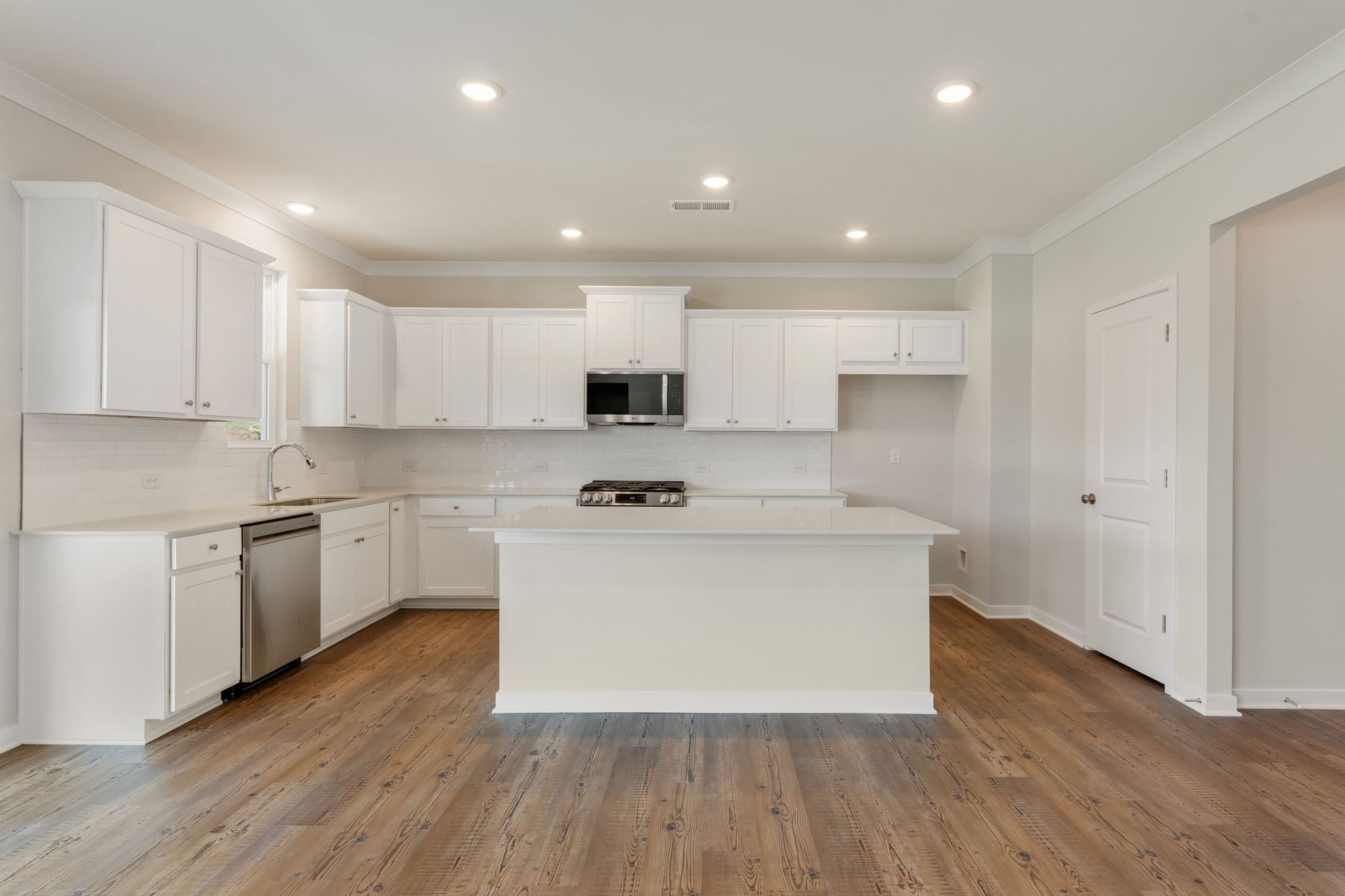 A kitchen with white cabinets.