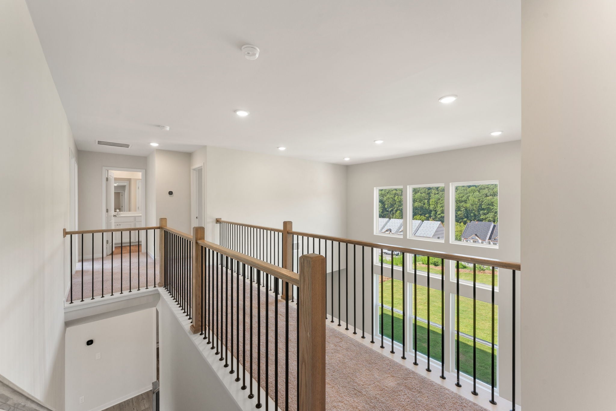 A large white house with a wood railing and a white wall.