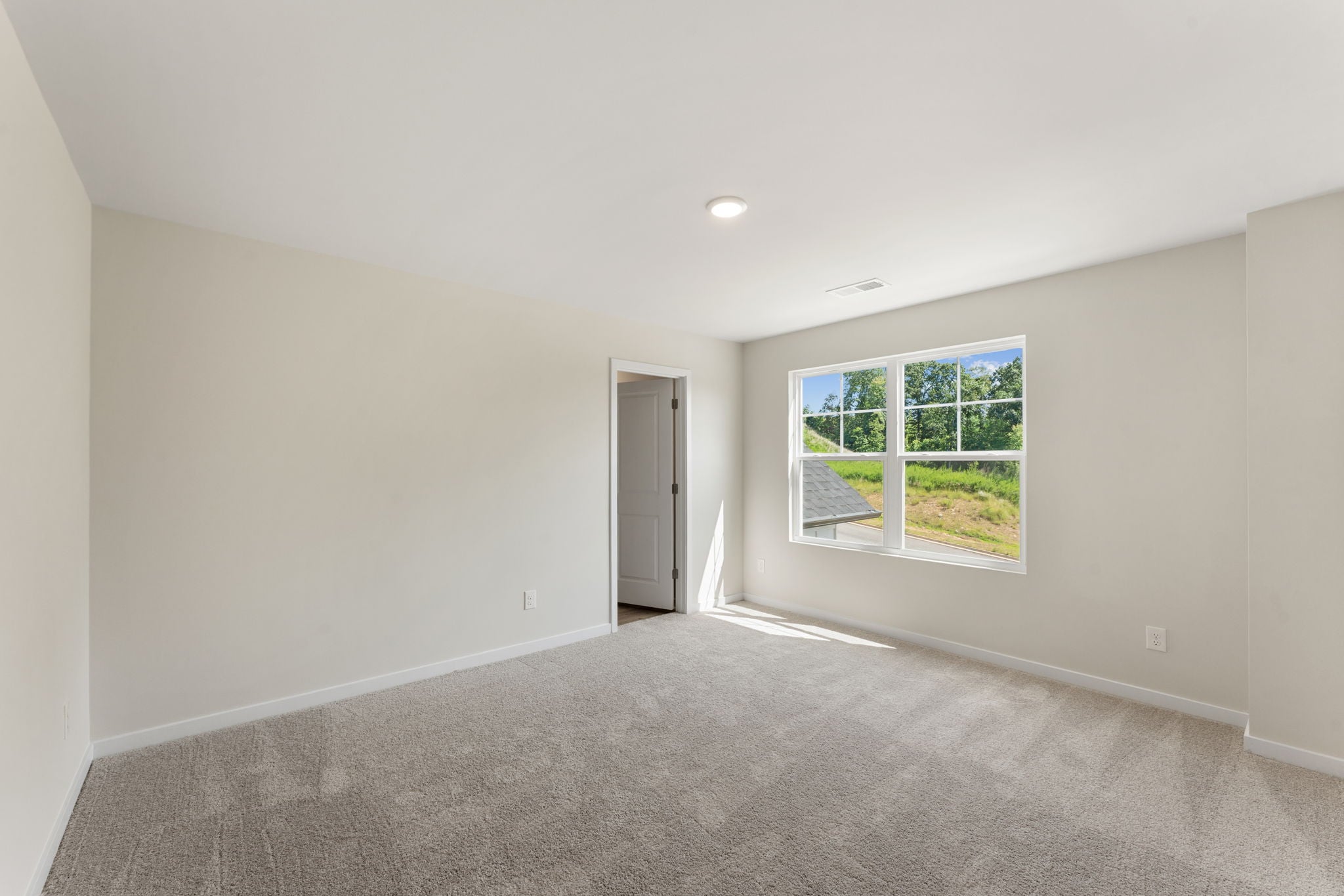 A room with a window and a carpet.