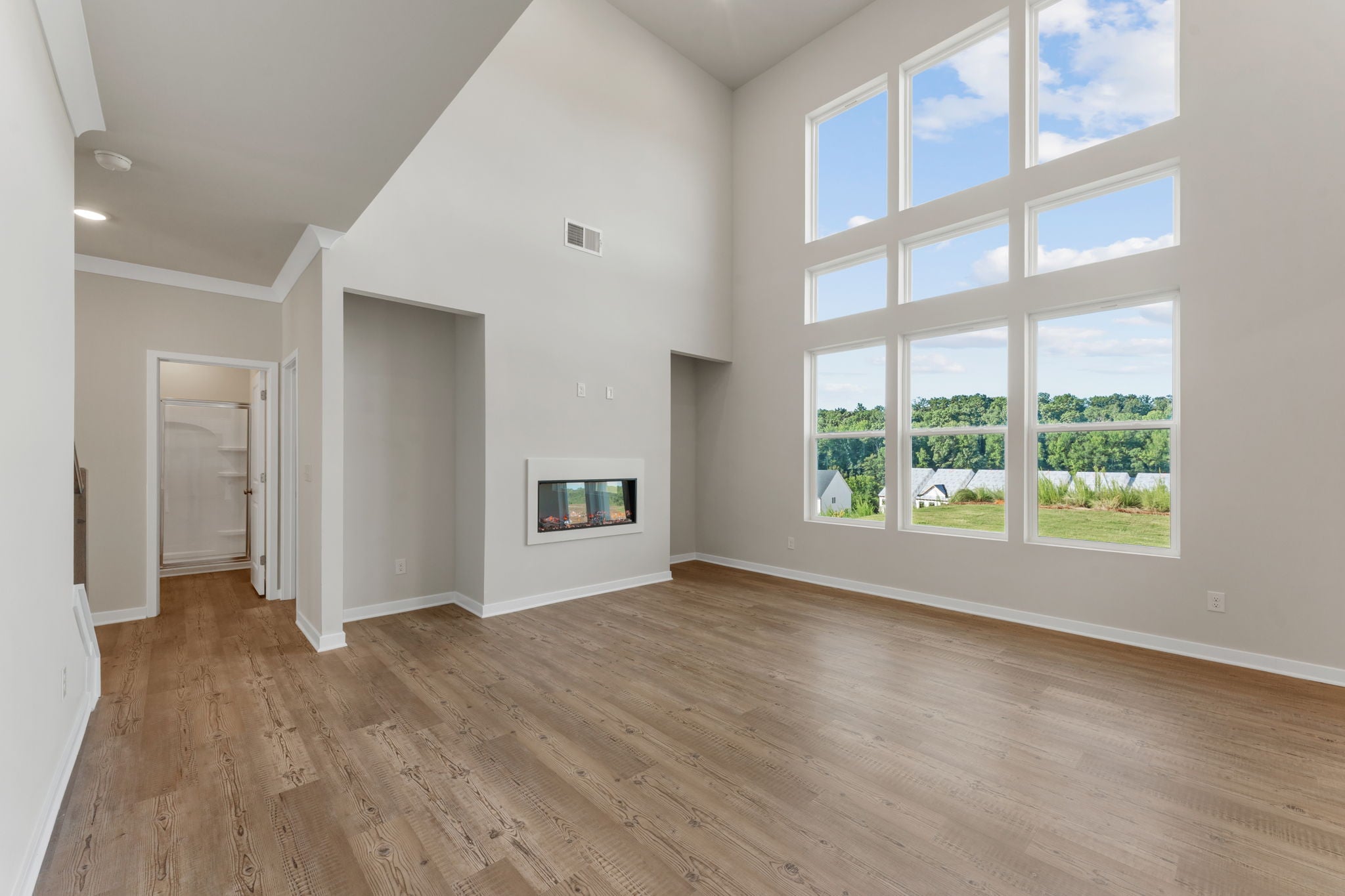 A room with a wood floor and a fireplace.