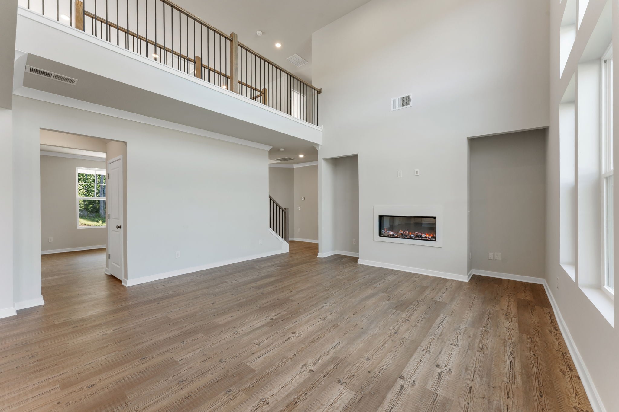 A room with a wood floor and a fireplace.