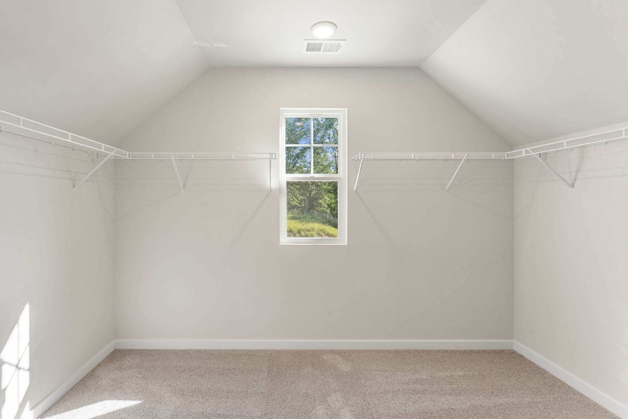 A room with a window and a carpet.