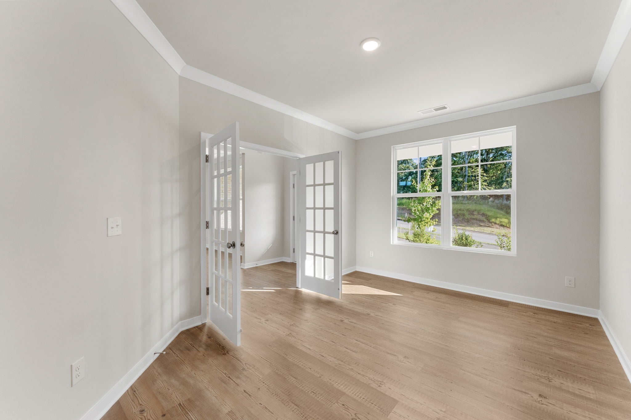 A room with a wood floor and a window.