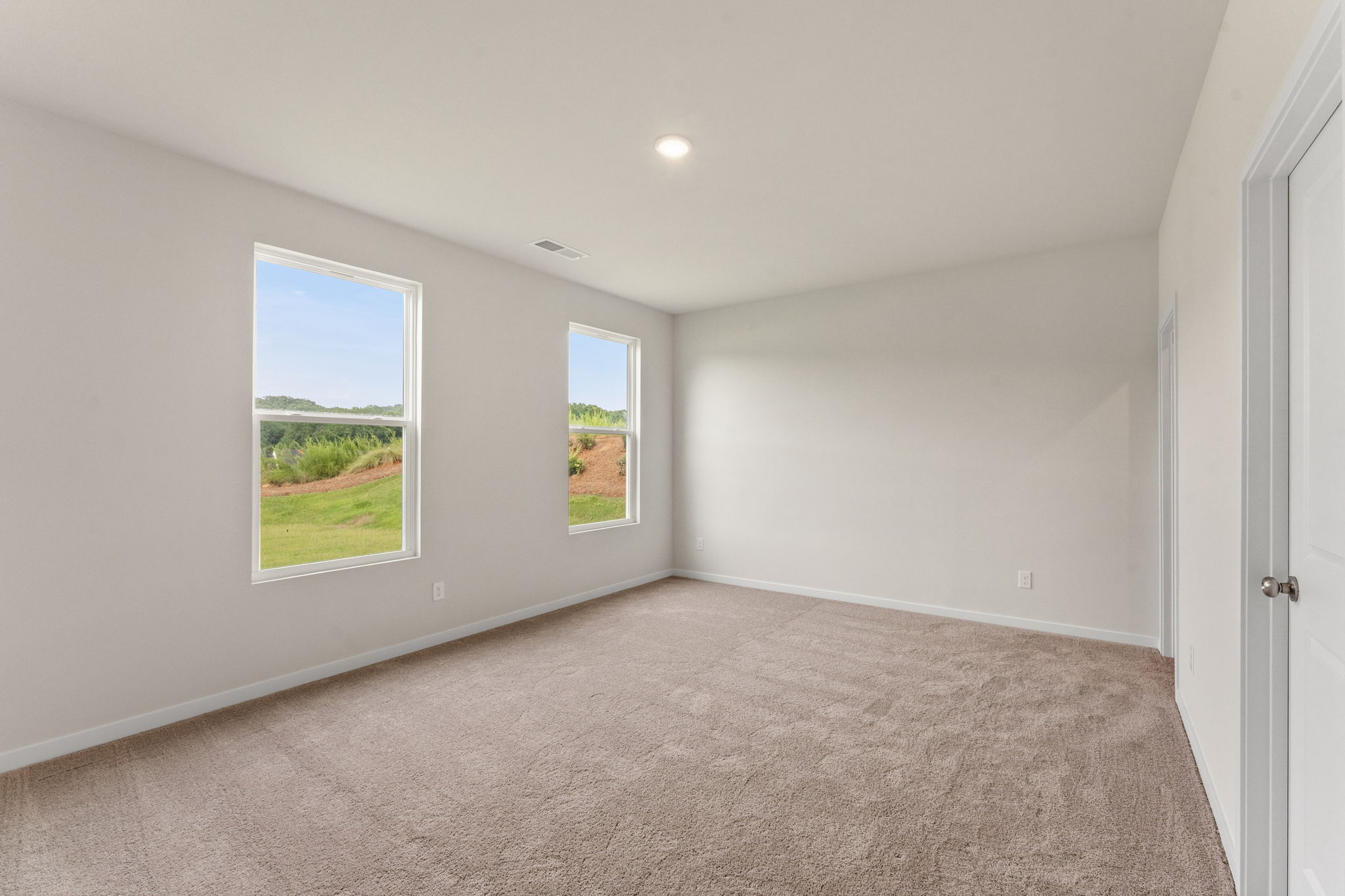 A room with a window and a carpet.