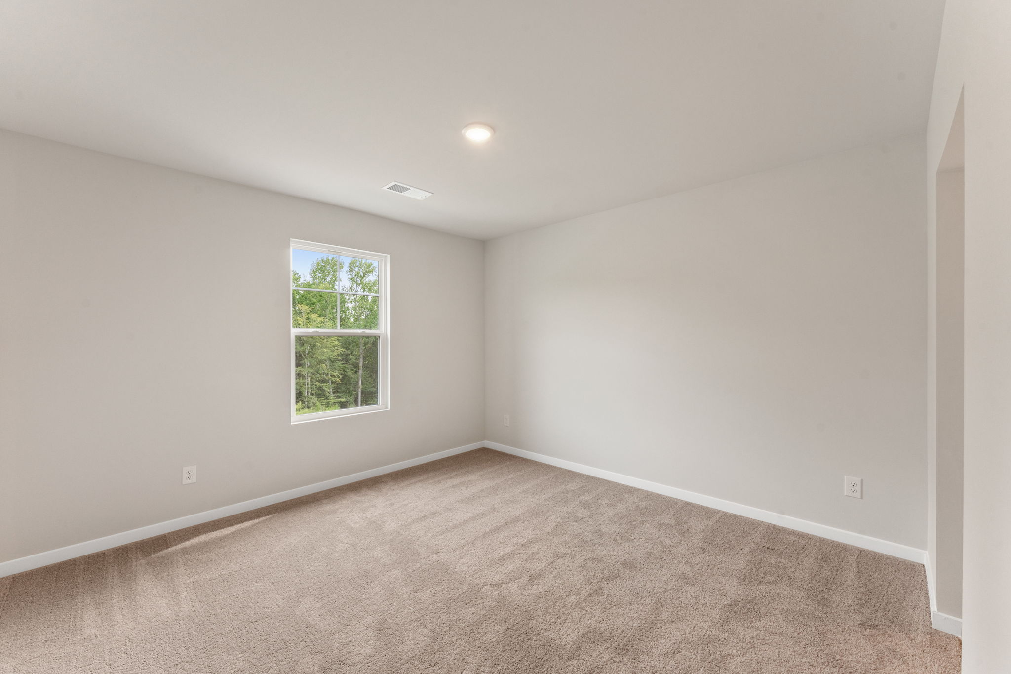 A room with a window and carpet.