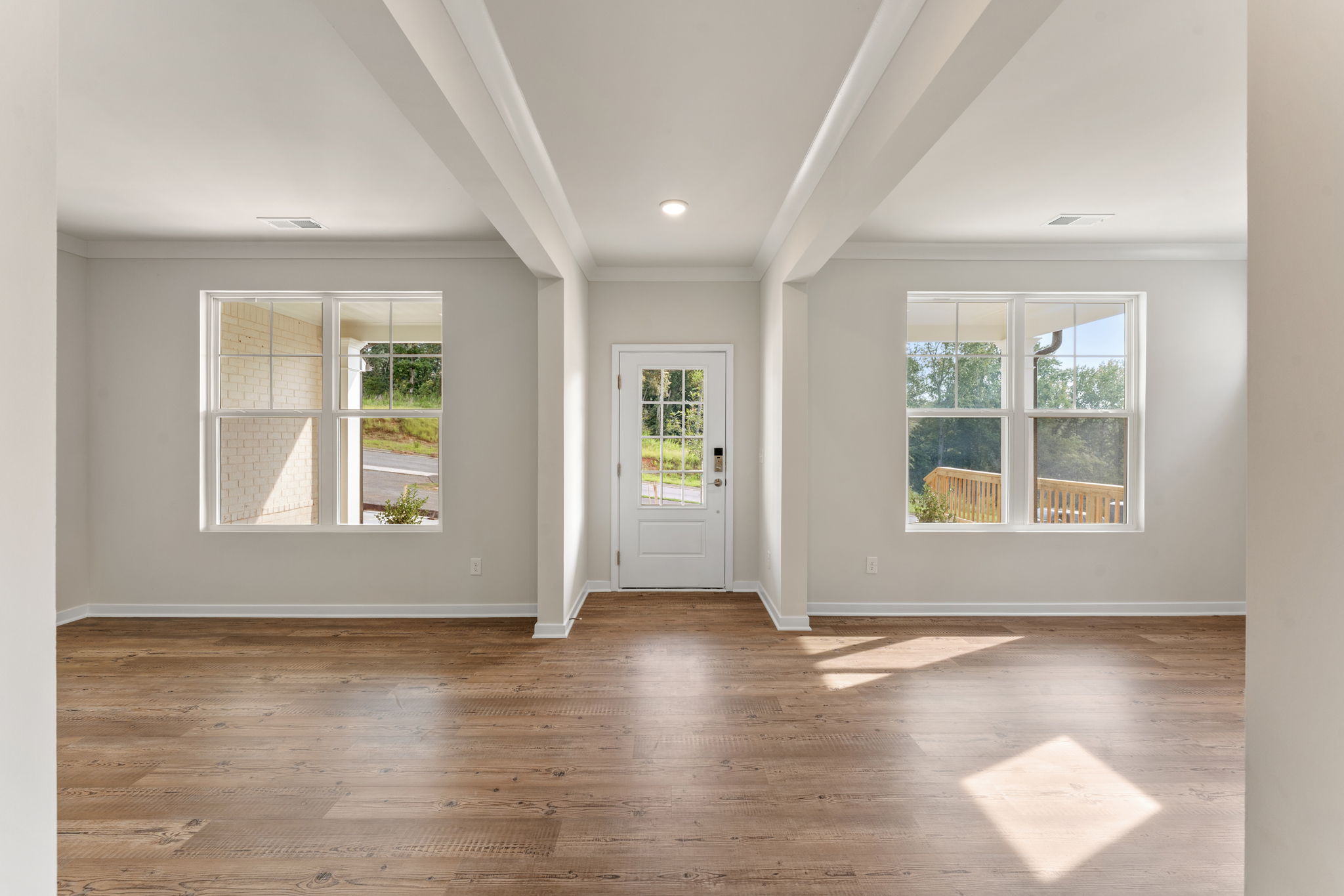 A room with windows and a wood floor.