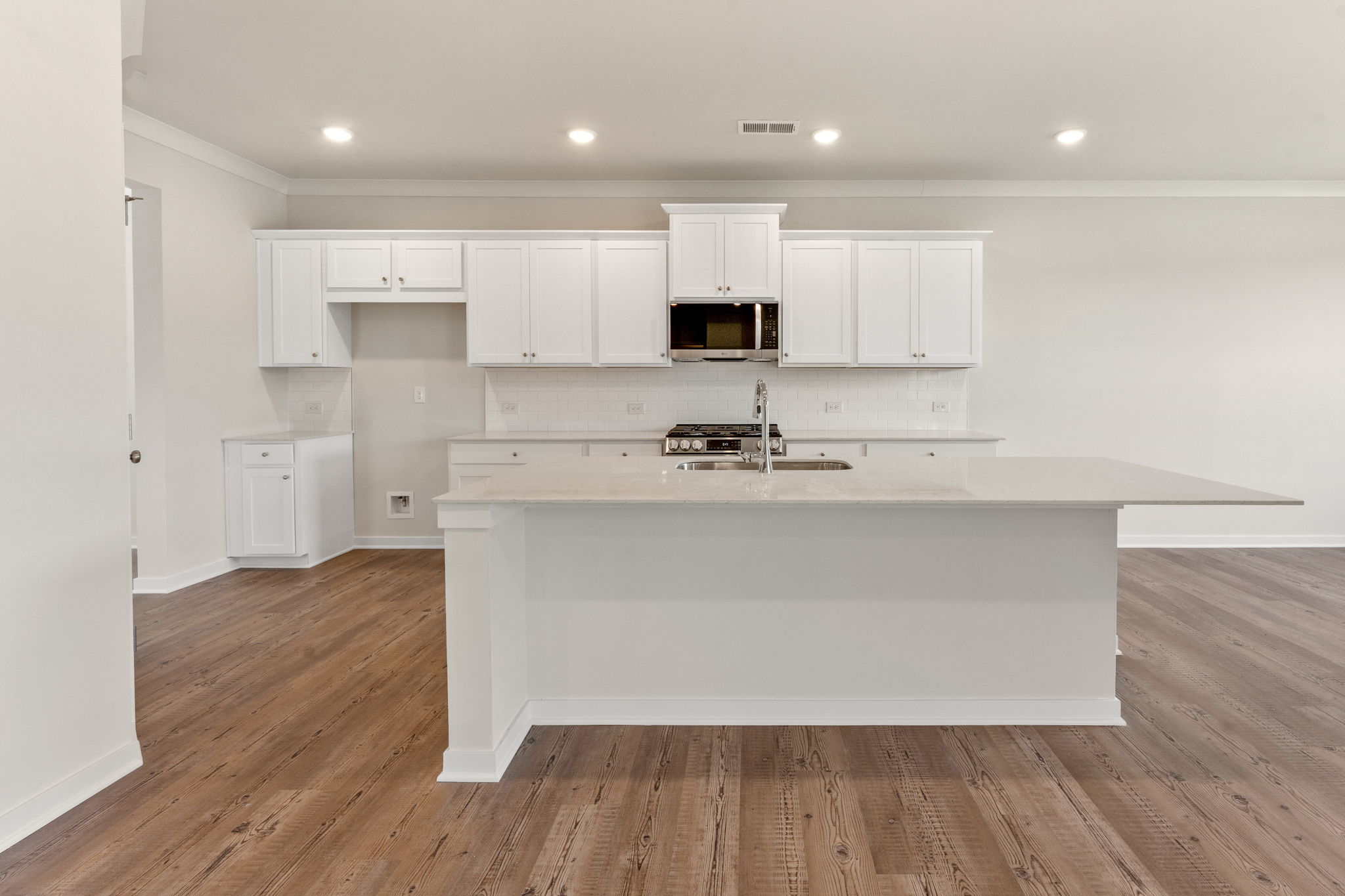 A kitchen with white cabinets.