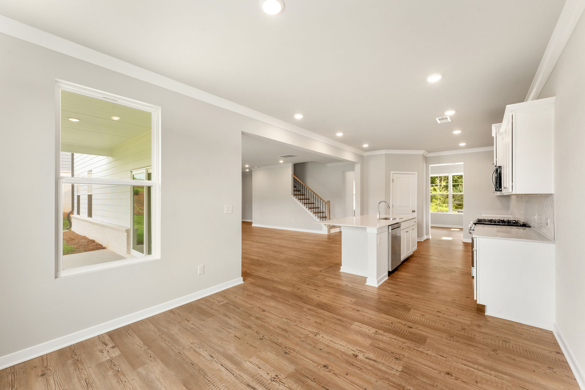 A large white room with a wood floor and a white wall.