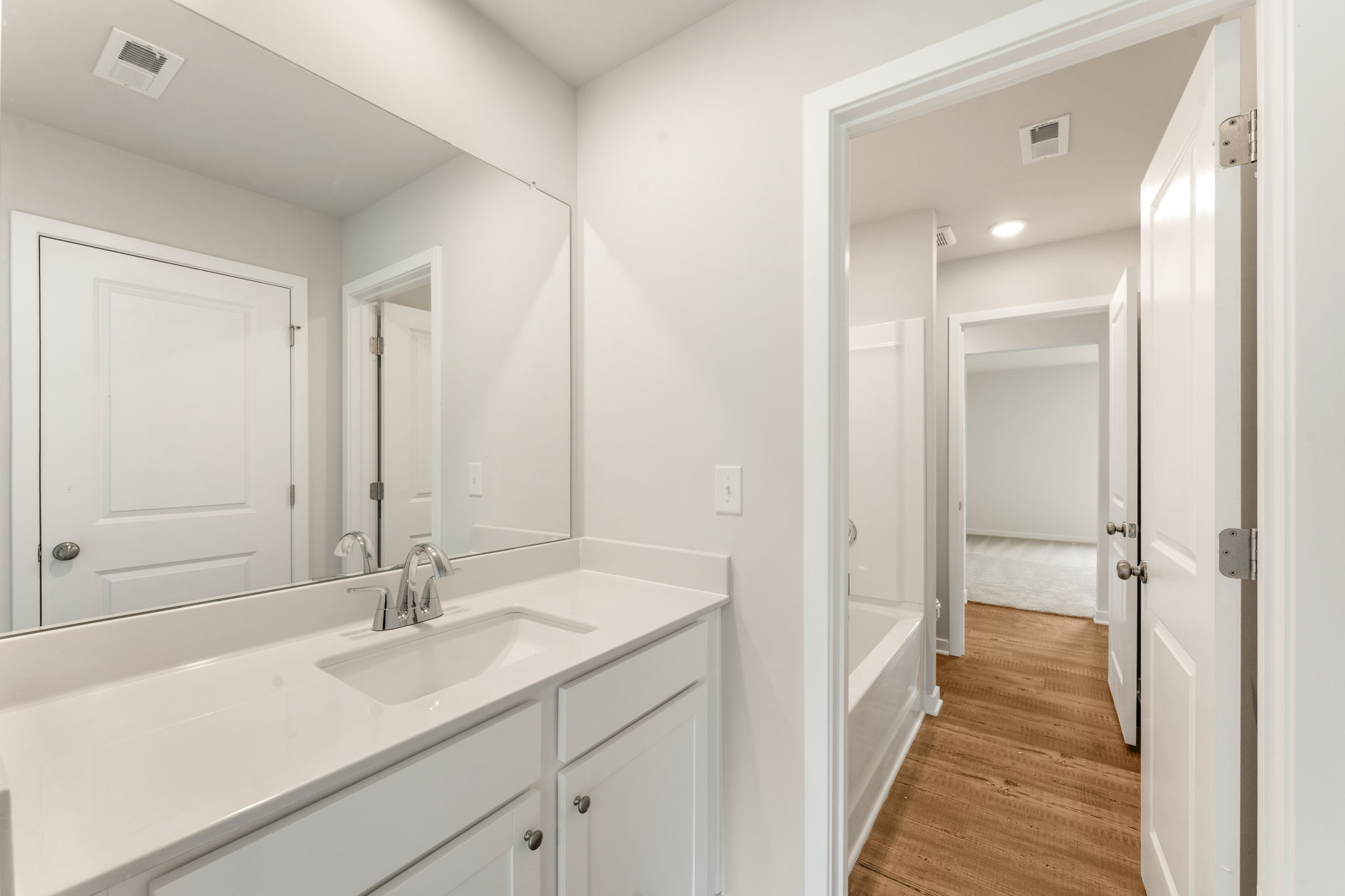A bathroom with white cabinets.