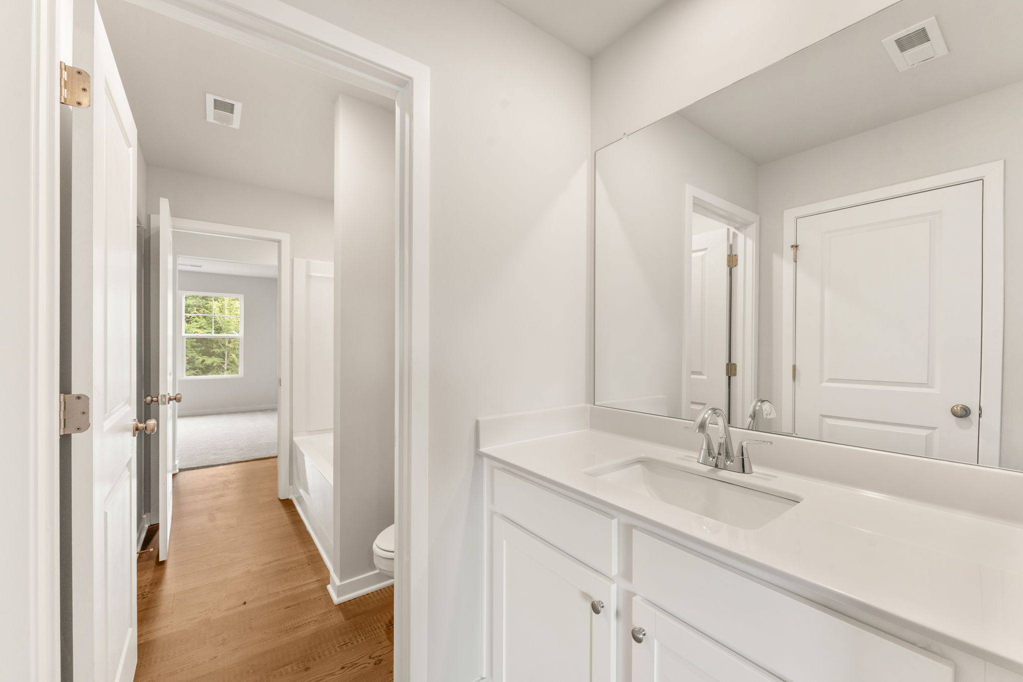 A bathroom with white cabinets.