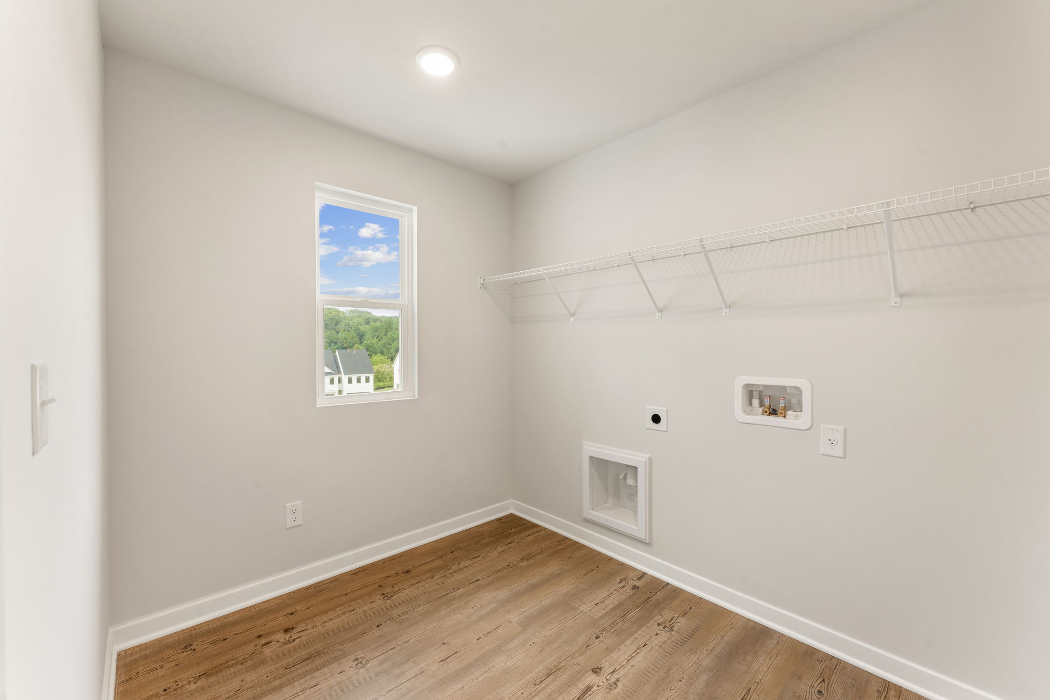 A room with a wood floor and a wood floor with a painting on the wall.