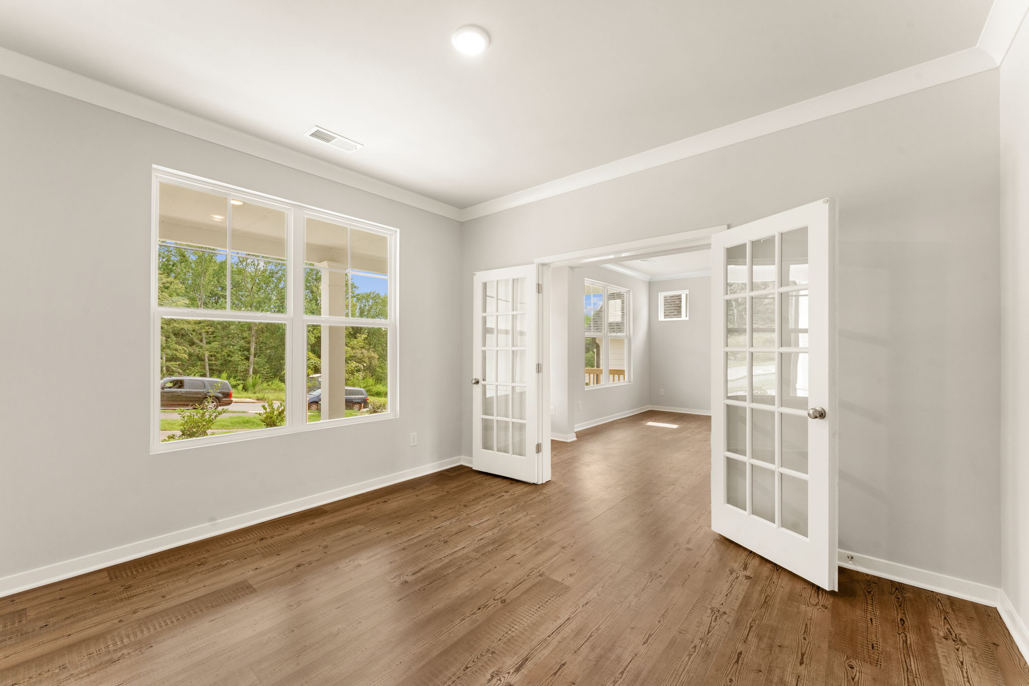 A room with a wood floor and a window.