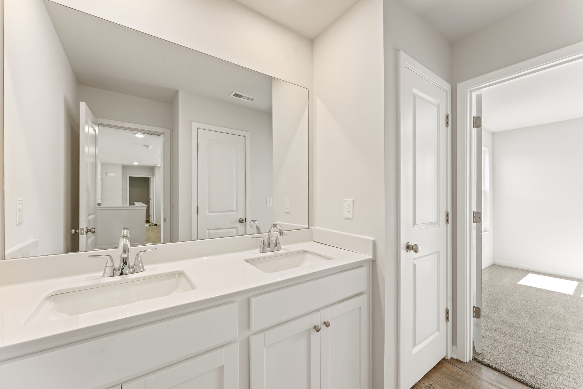 A bathroom with white cabinets.