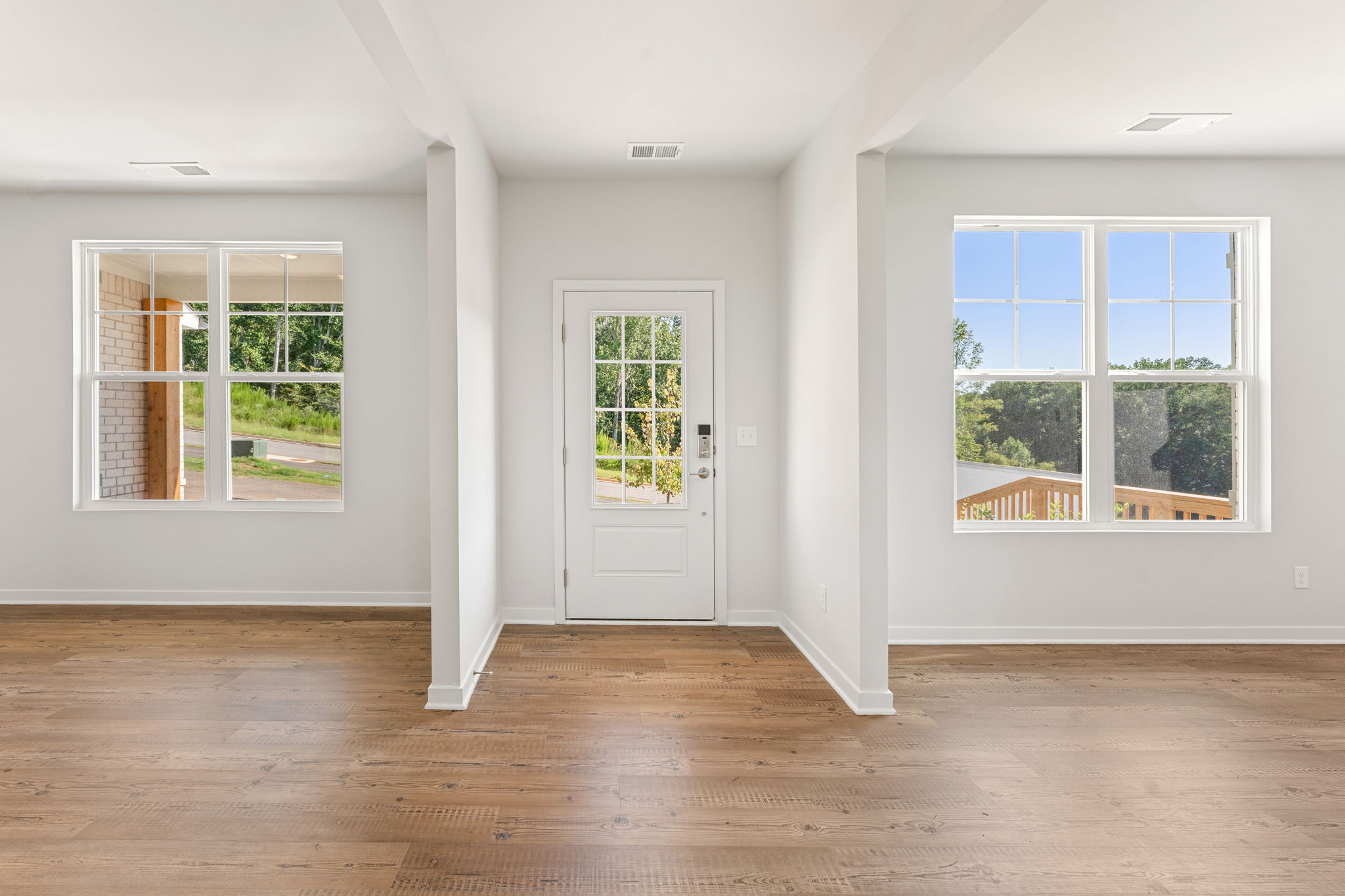 A room with windows and a wood floor.