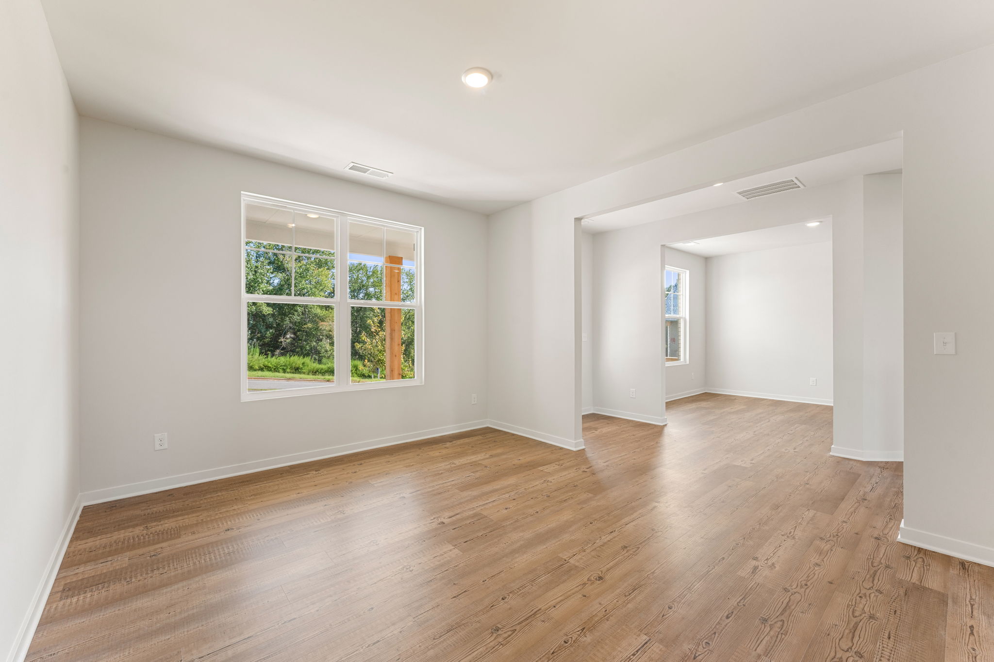 A room with a wood floor and a window.