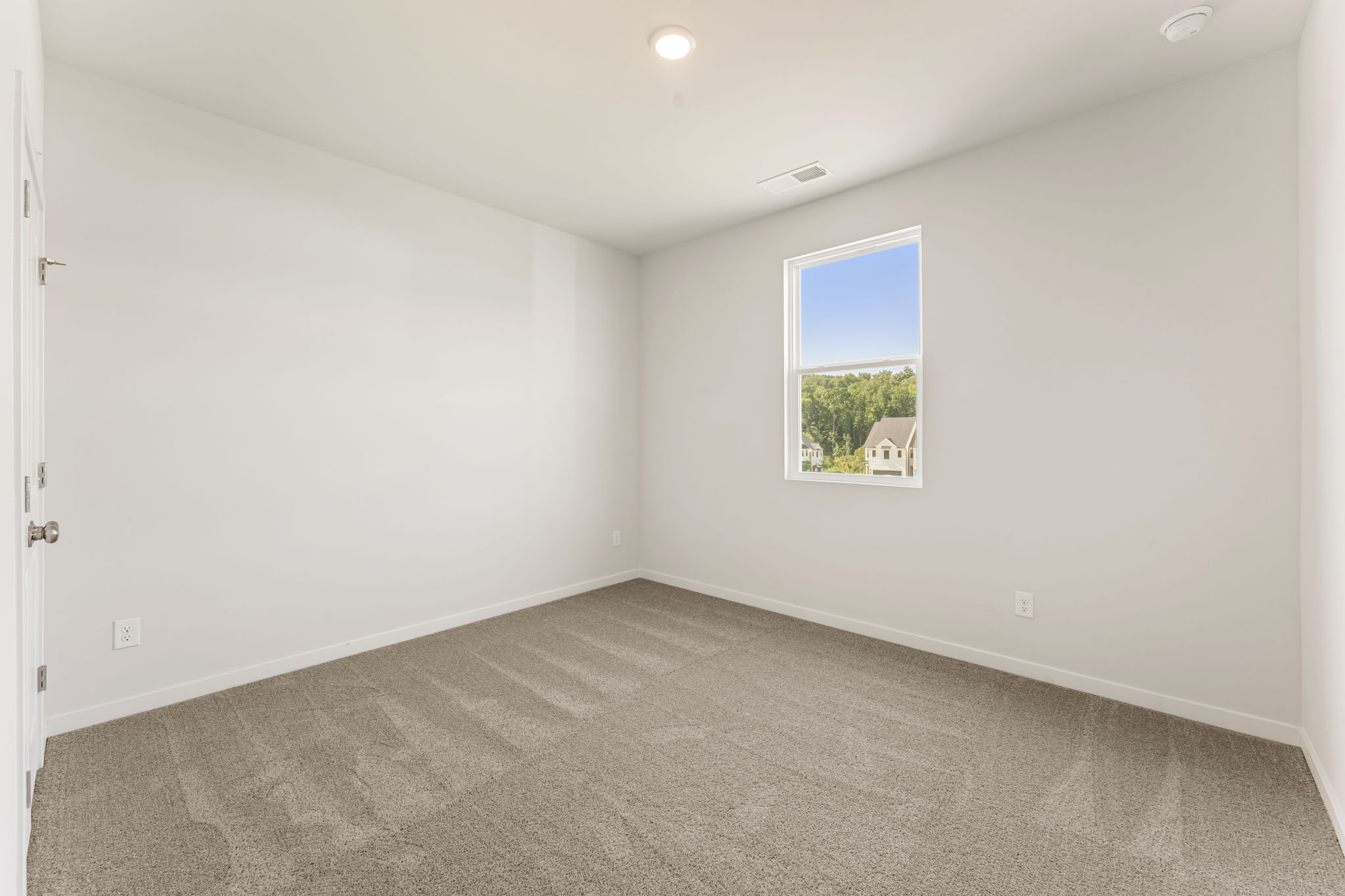 A room with a window and a picture on the wall.