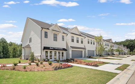 A large white house with a lawn.