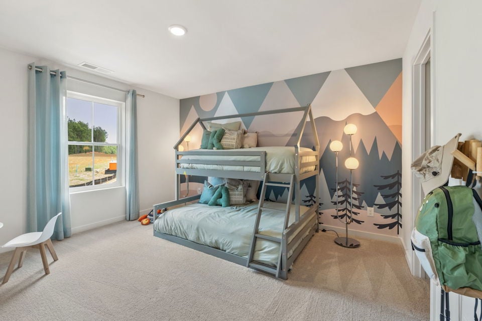 A bedroom with a bed and a chair.