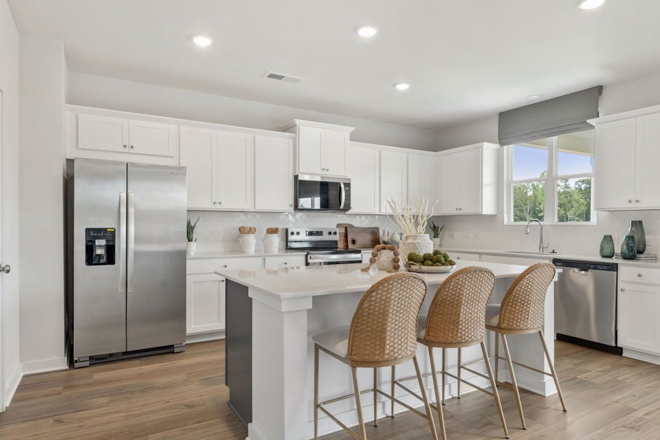 A kitchen with white cabinets.