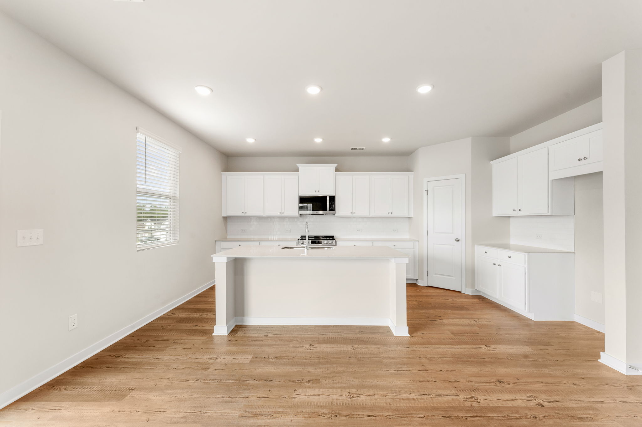 A kitchen with white cabinets.