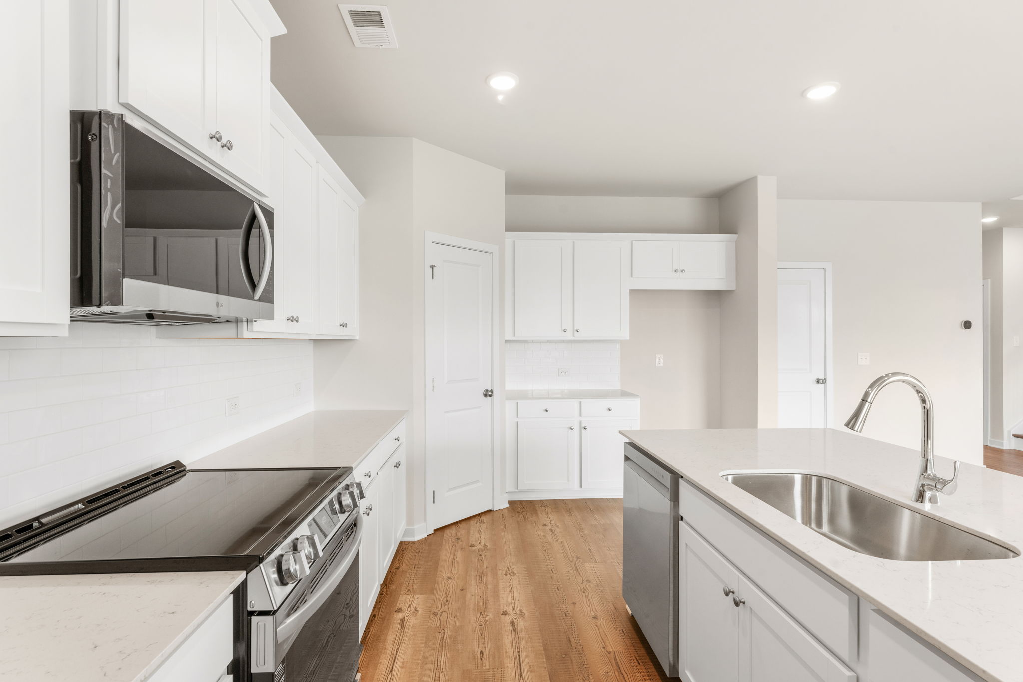 A kitchen with white cabinets.