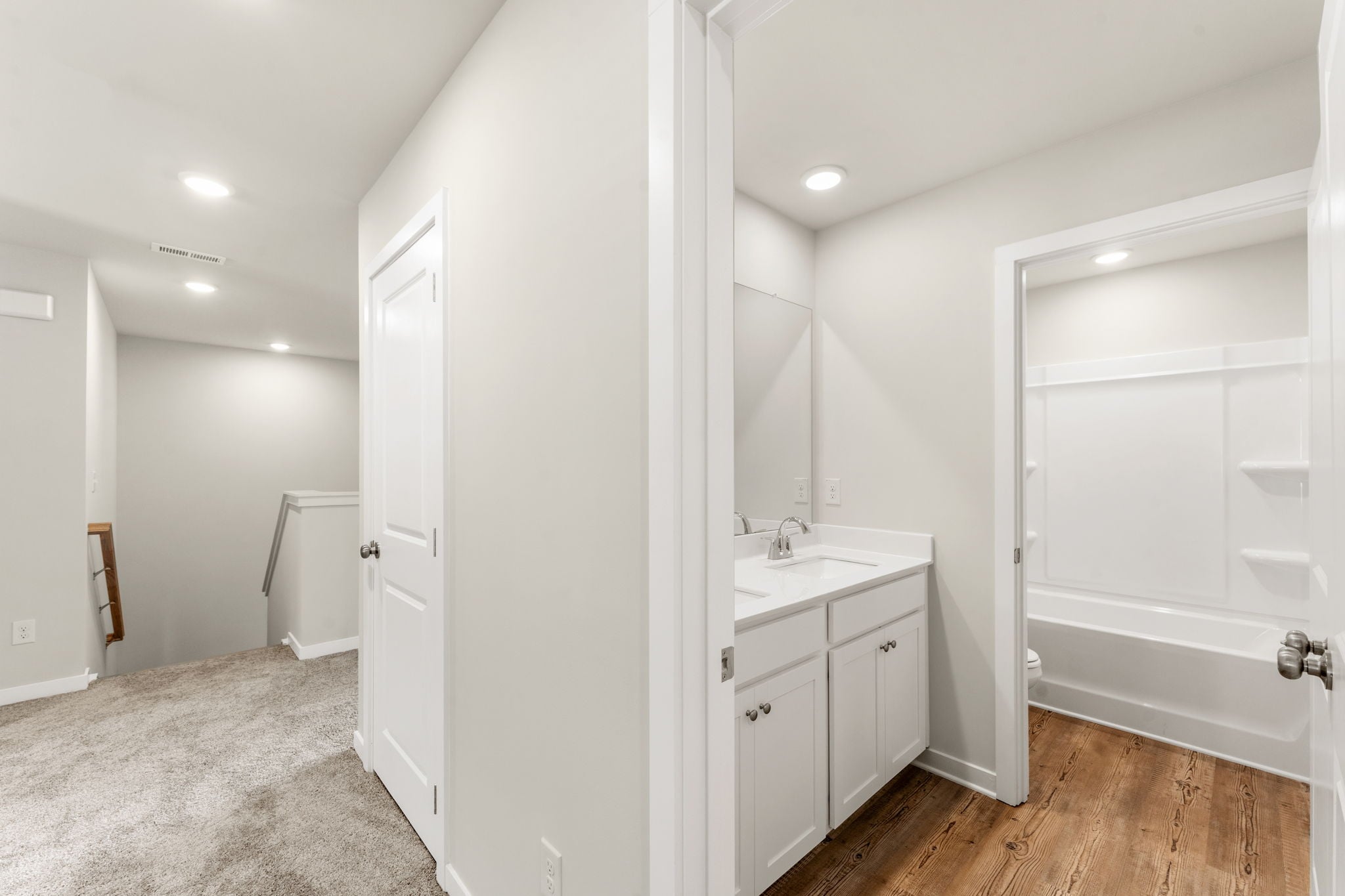 A bathroom with white cabinets.