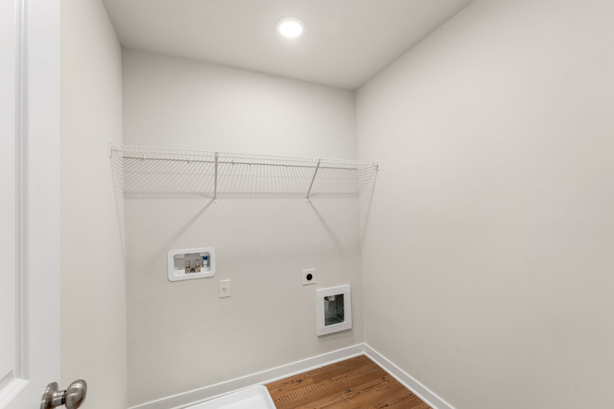 A white room with a shower and a rug.
