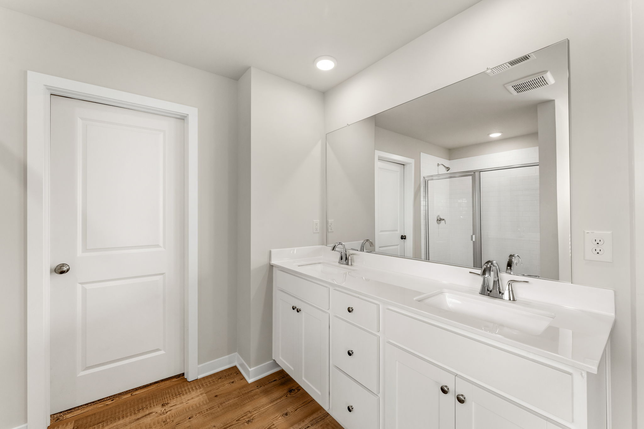 A bathroom with white cabinets.