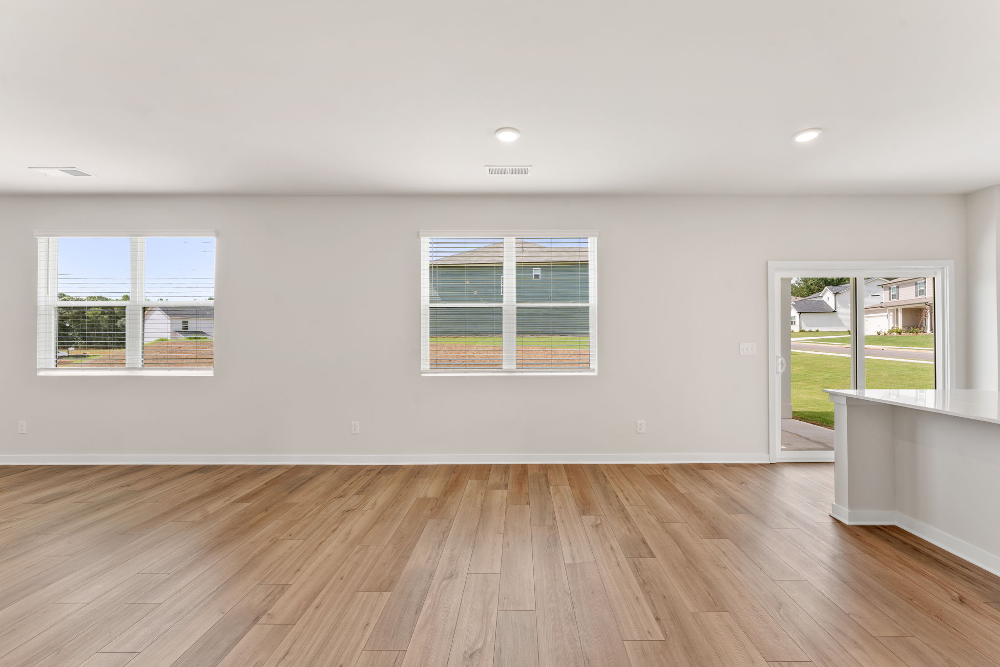 A room with windows and a wood floor.