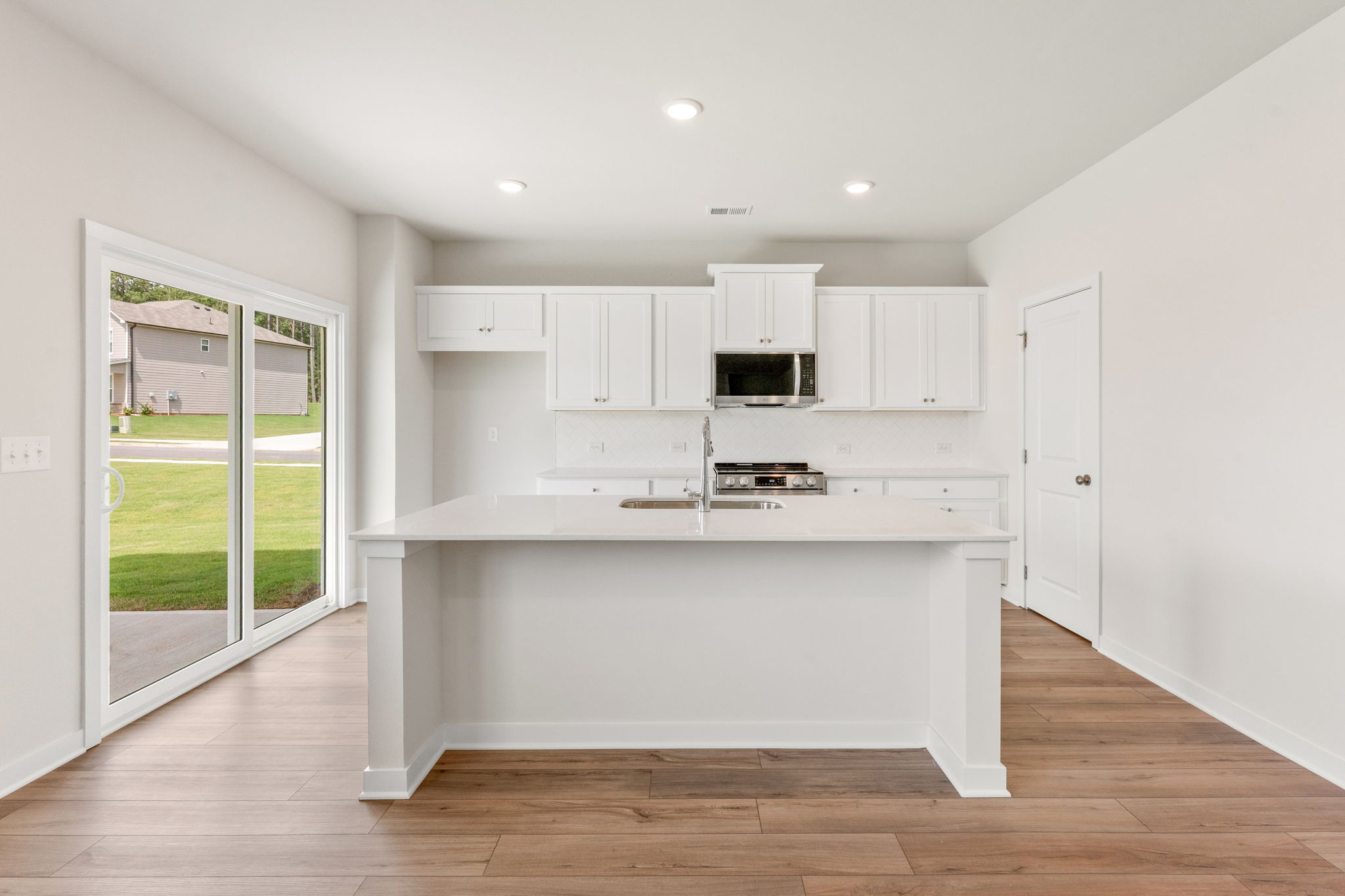 A kitchen with white cabinets.