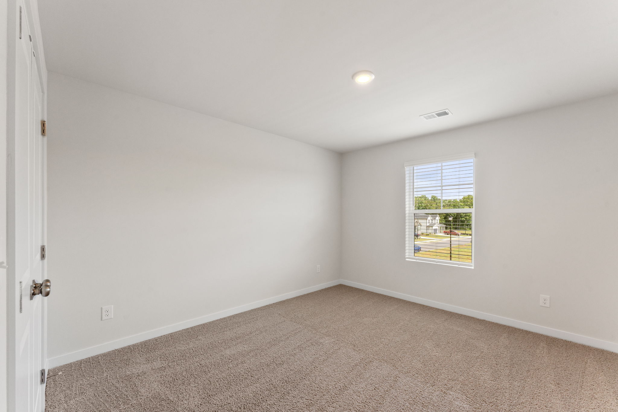 A room with a window and carpet.
